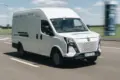 Weißer ARI 1710 Elektro-Transporter fährt auf einer Landstraße bei Tageslicht.
