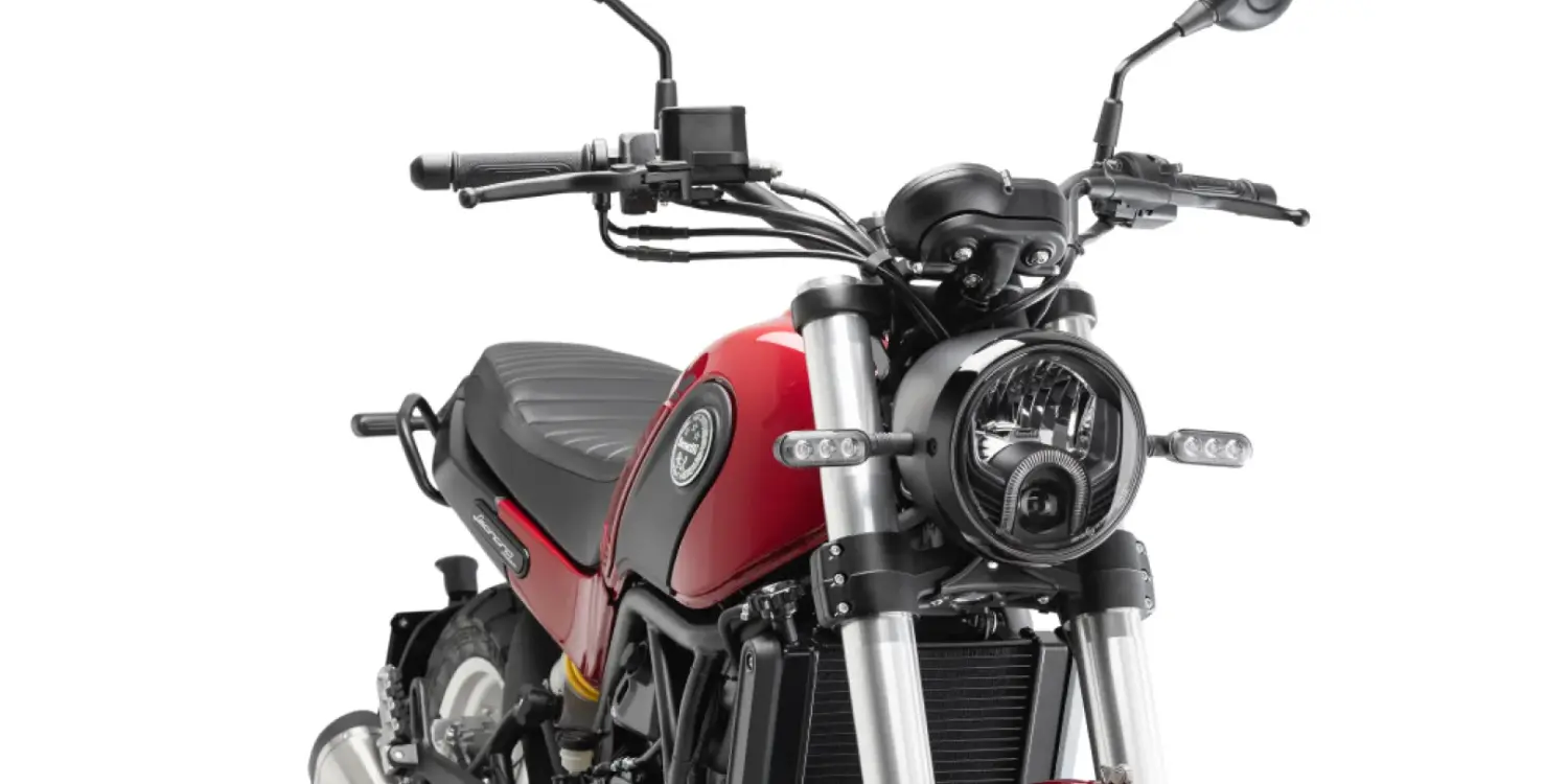 Frontansicht der Benelli Leoncino 500 Trail in roter Lackierung, Motorrad mit markantem Rundscheinwerfer und Speichenrädern.