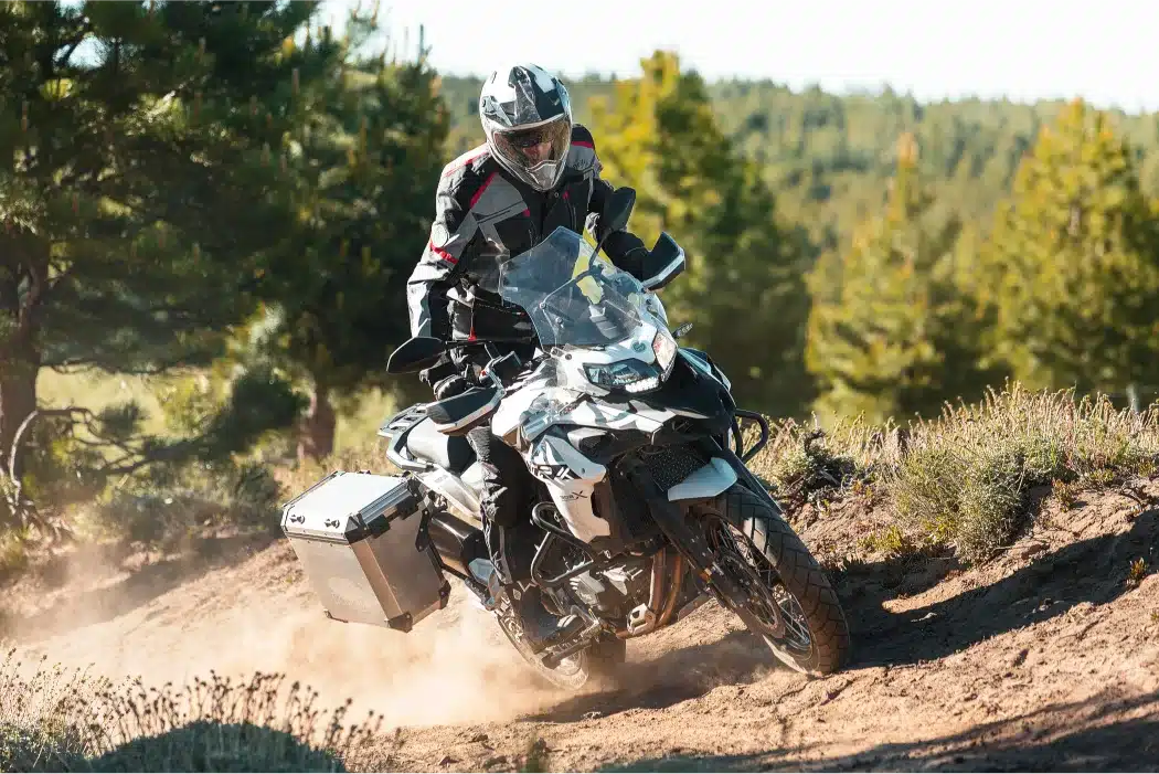 Motorradfahrer mit Benelli TRK 502 X auf einer Schotterpiste im Wald