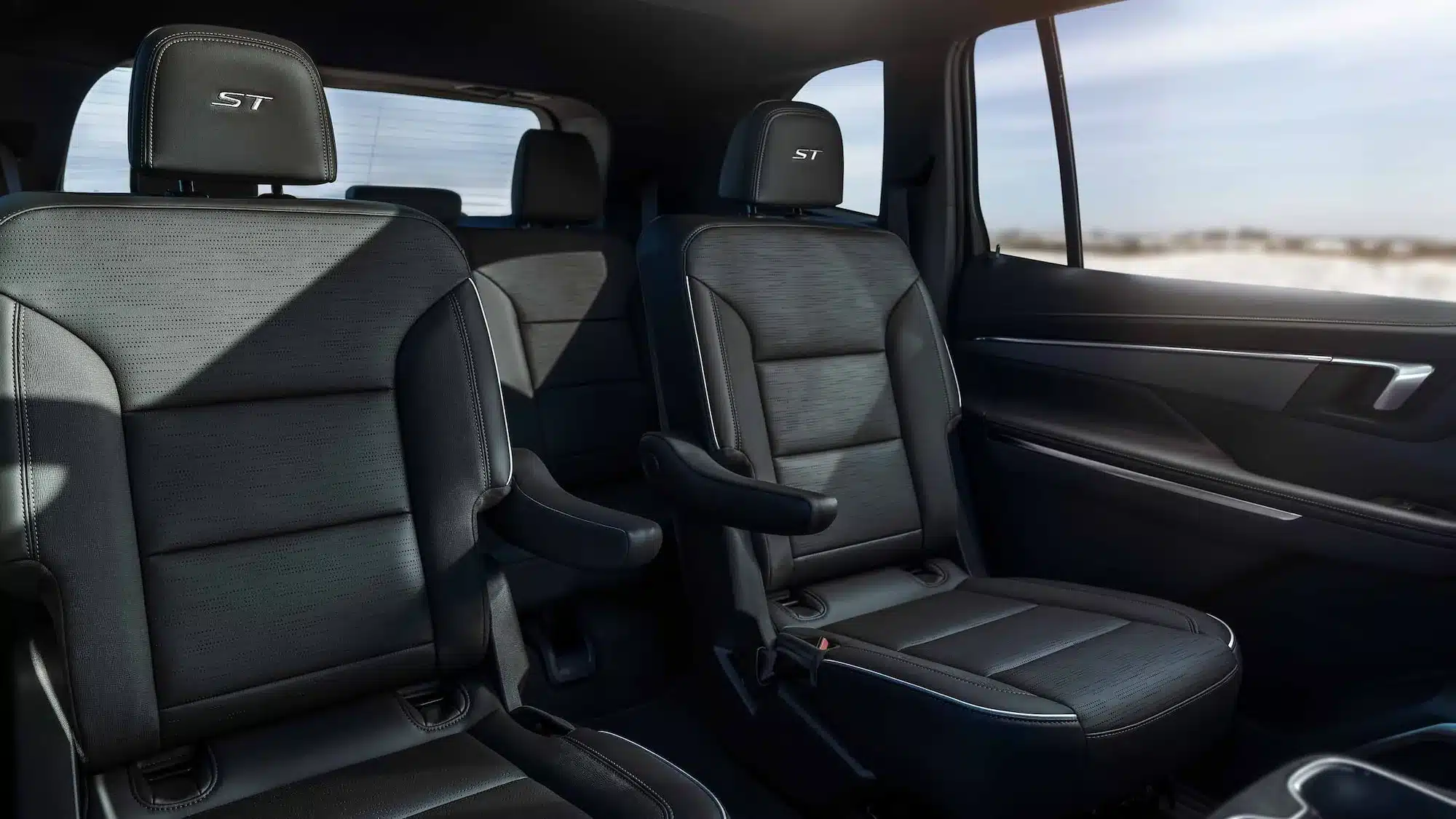 Sitzreihe zwei mit Einzelsitzen im Buick Enclave ST, schwarzes Leder mit weißen Nähten und ST-Emblem auf den Kopfstützen.