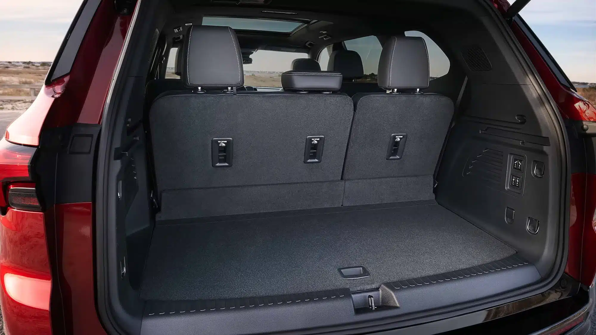 Blick in den Kofferraum eines Buick Enclave mit aufrechter dritter Sitzreihe und großzügigem Ladevolumen.