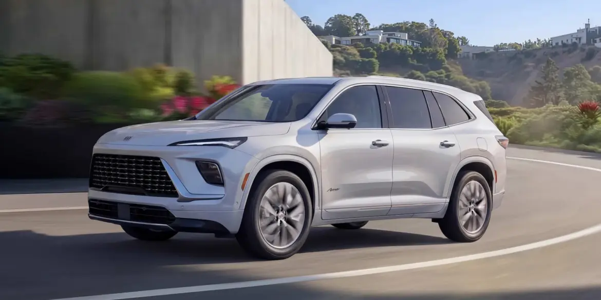 Buick Enclave Avenir 2025 fährt auf einer modernen Straße entlang, Seitenansicht des Fahrzeugs.