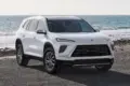 Buick Enclave 2026 in Weiß von vorn am Meer geparkt.