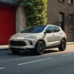 2026 Buick Encore GX SUV in heller Lackierung fährt eine städtische Straße entlang.