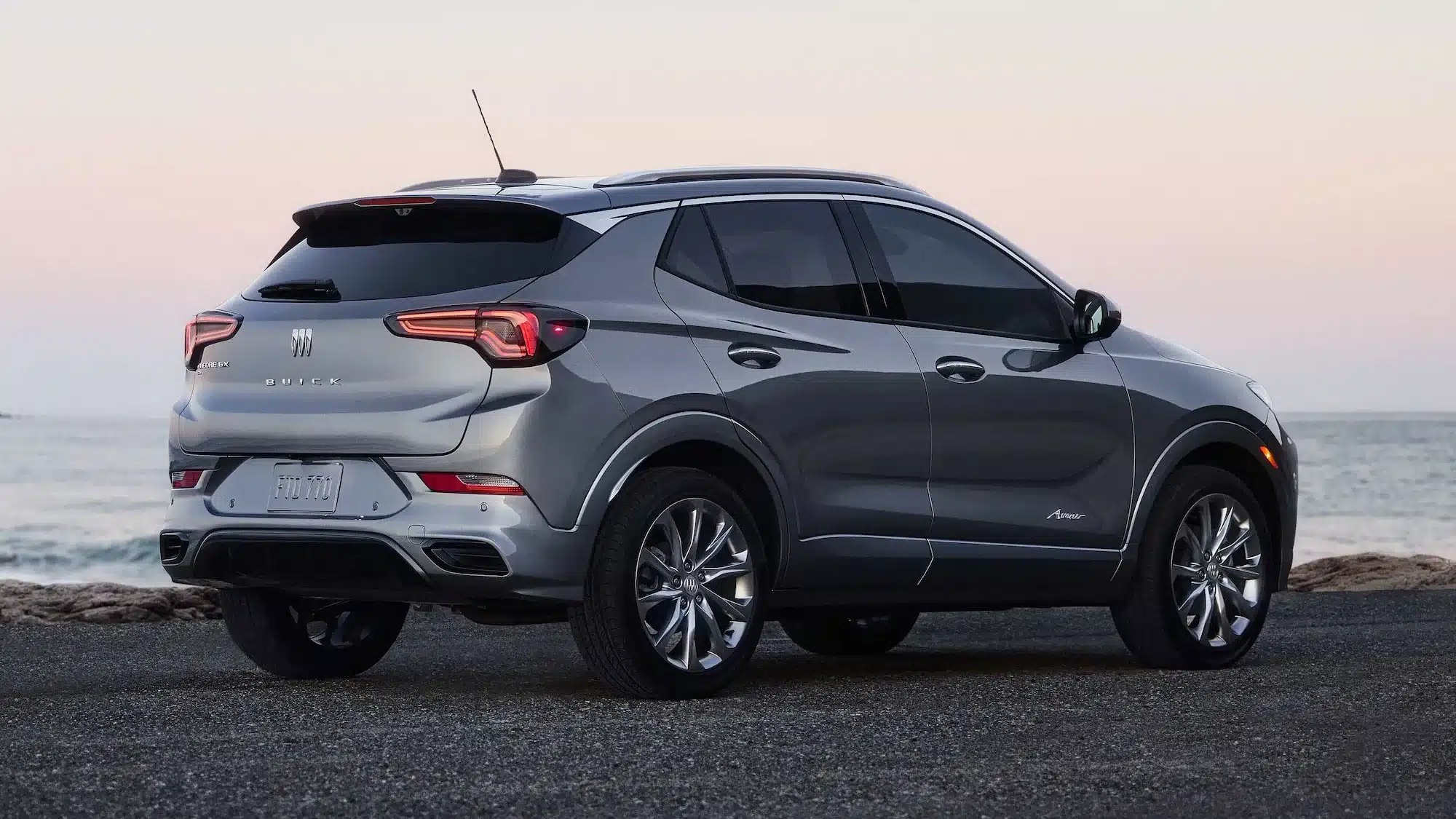 Heckansicht eines silbernen 2026 Buick Encore GX Avenir SUV an der Küste