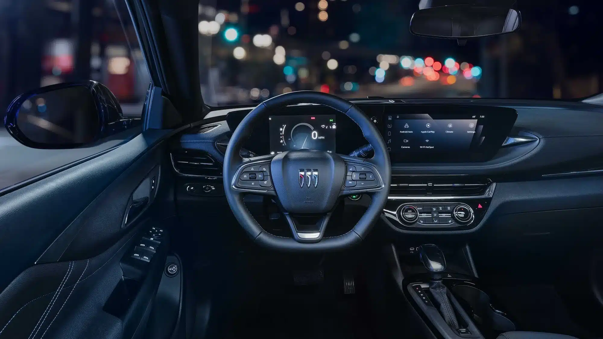 Innenraum des Buick Envista 2026 mit Lenkrad, Display und Mittelkonsole bei Nacht.