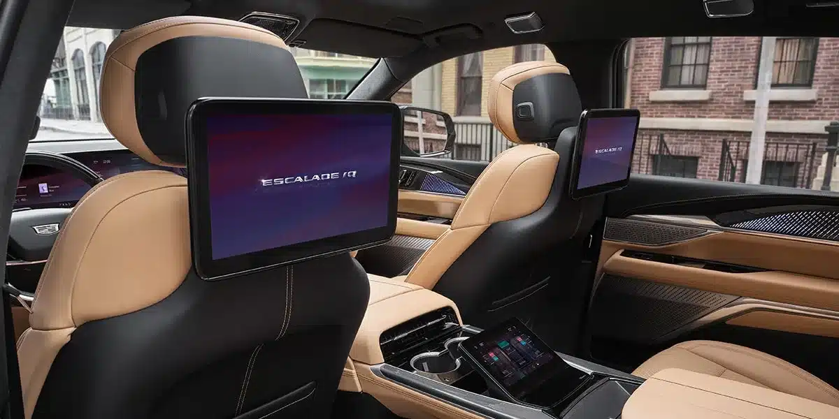 Innenraum des Cadillac Escalade IQ zeigt Bildschirme an den Rücksitzen und hochwertige Lederausstattung.