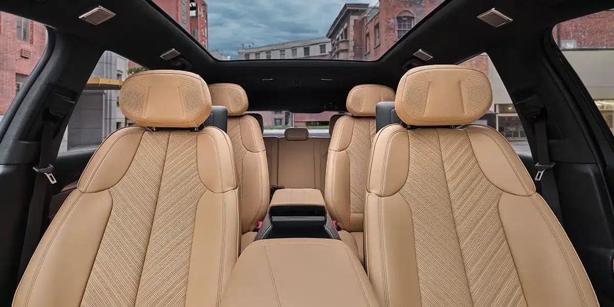 Der komfortable Innenraum des Cadillac Escalade IQ mit drei Reihen beiger Ledersitze und Panoramadach