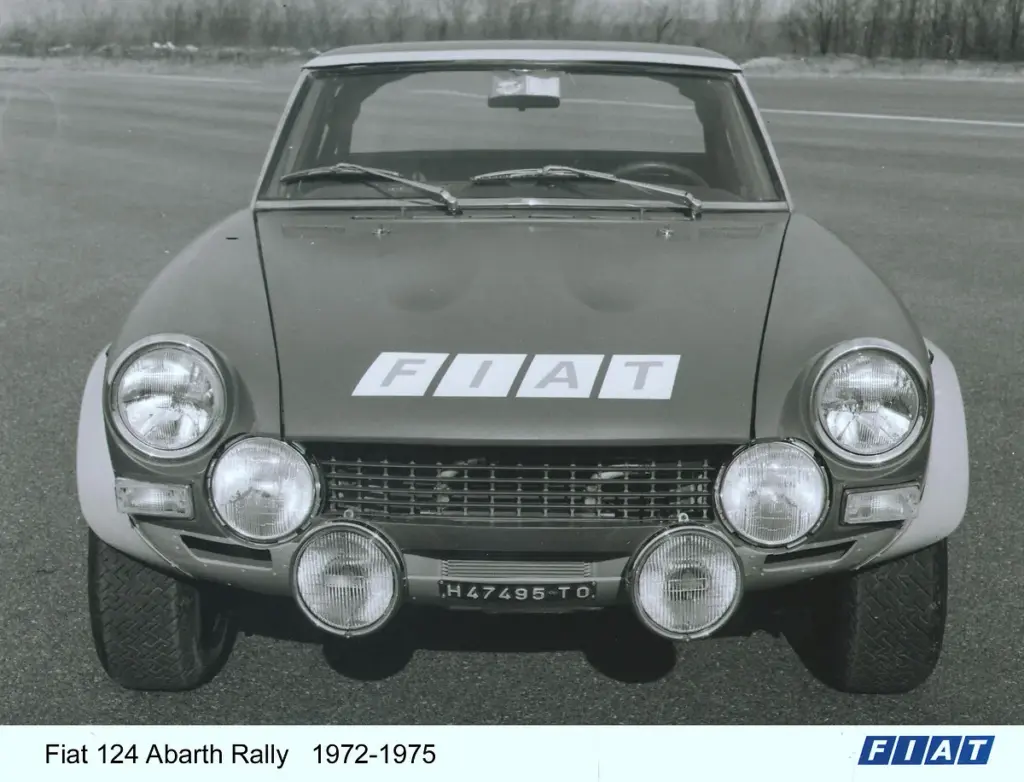 Schwarzweißaufnahme eines Fiat 124 Abarth Rally mit vier Zusatzscheinwerfern an der Front, Baujahr 1972-1975.