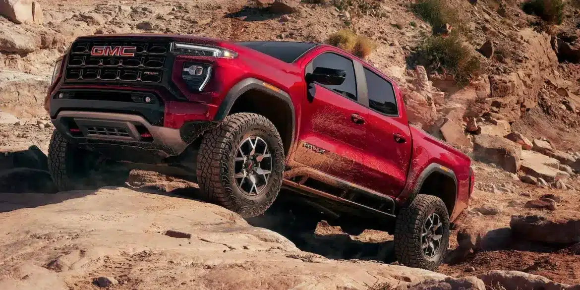 Roter GMC Canyon AT4X 2026 fährt über felsiges Gelände mit ausgeprägter Offroad-Optik.