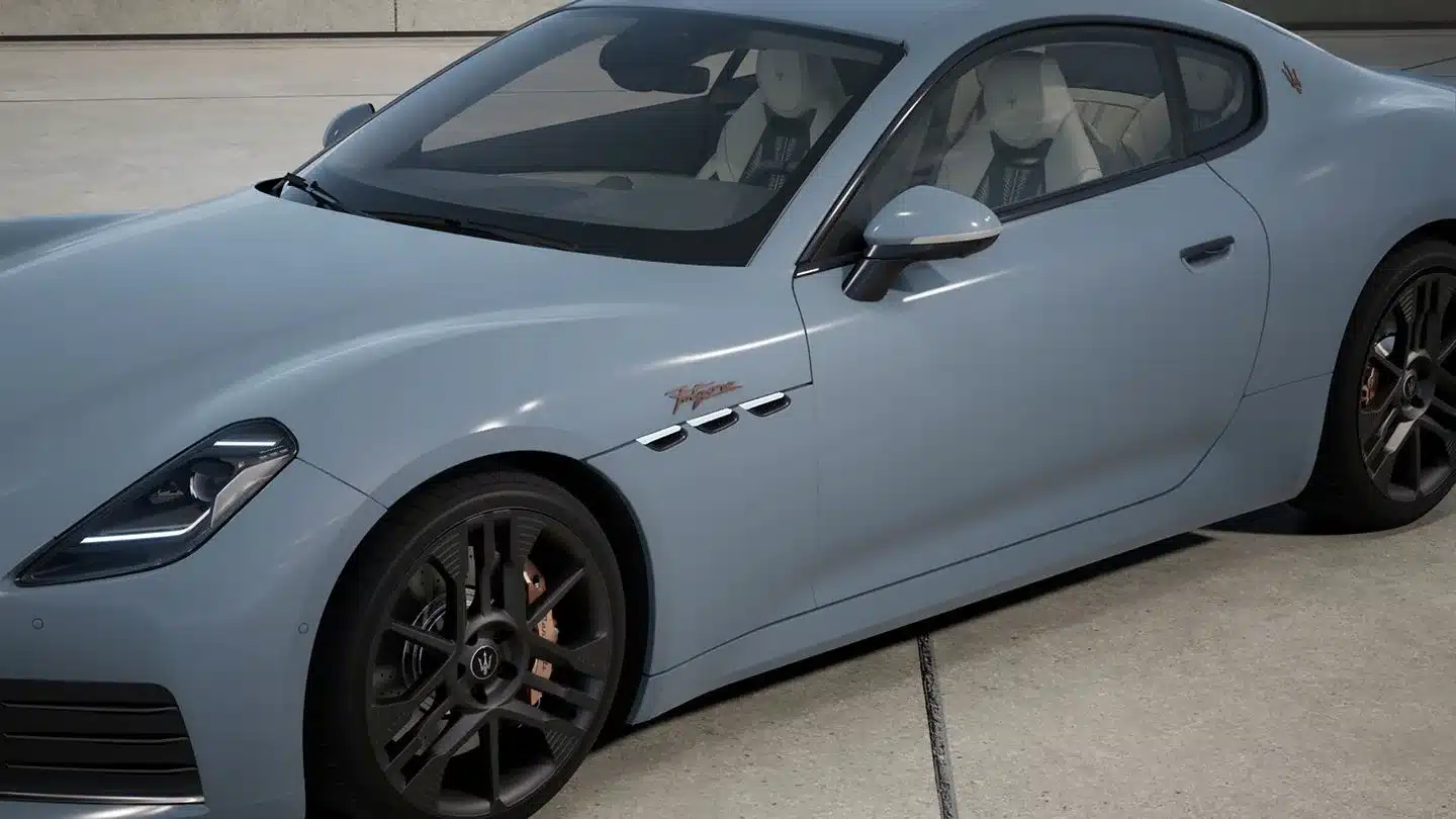 Detailaufnahme des Maserati GranTurismo Folgore in hellblau mit sichtbaren kupferfarbenen Emblemen und sportlichem Design.