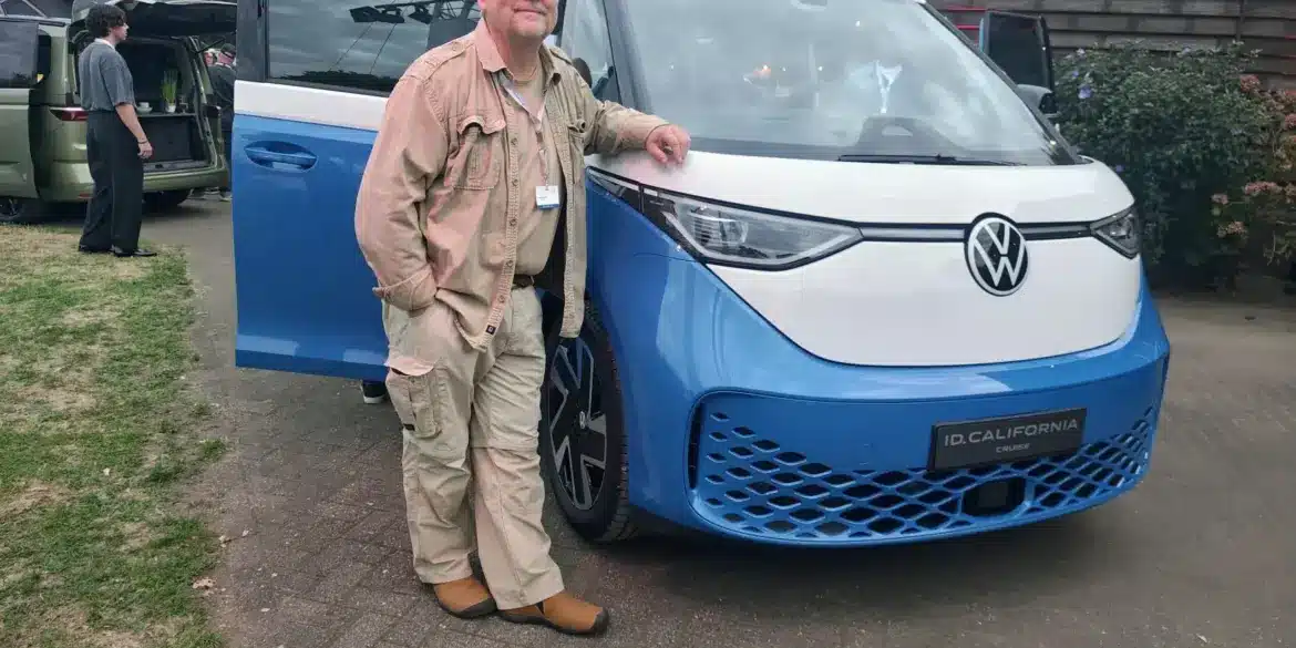 Person steht vor dem Volkswagen ID. California Cruise Campervan, fotografiert bei Tageslicht