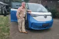 Person steht vor dem Volkswagen ID. California Cruise Campervan, fotografiert bei Tageslicht