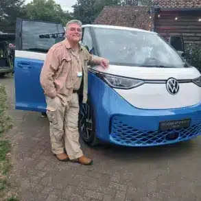 Person steht vor dem Volkswagen ID. California Cruise Campervan, fotografiert bei Tageslicht