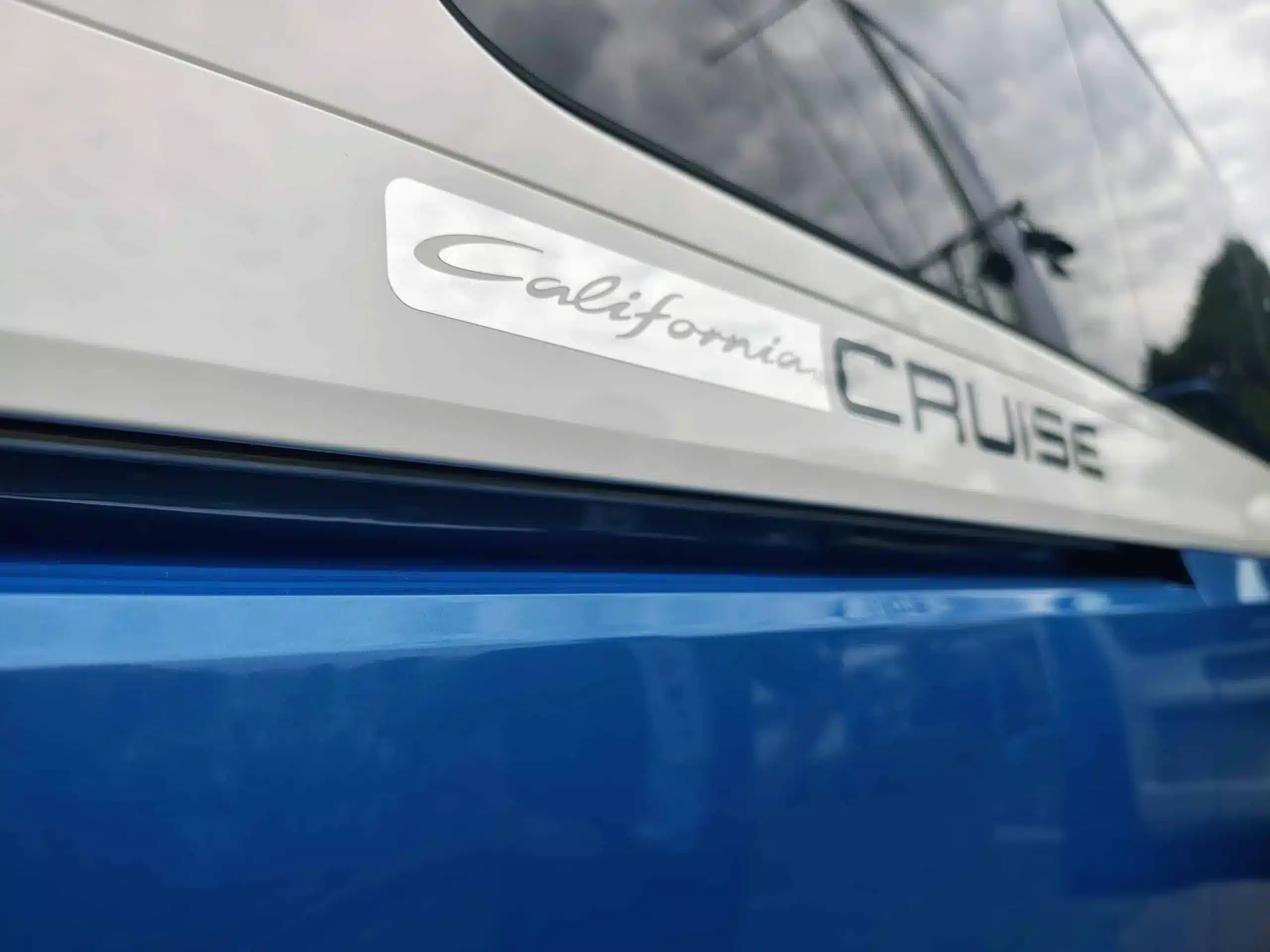 Schriftzug 'California Cruise' an der Fahrzeugseite des Volkswagen ID. California Cruise in Blau und Weiß
