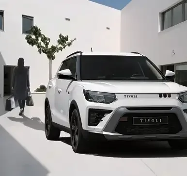 KGM Tivoli SUV, frontal fotografiert, vor moderner weißer Architektur.
