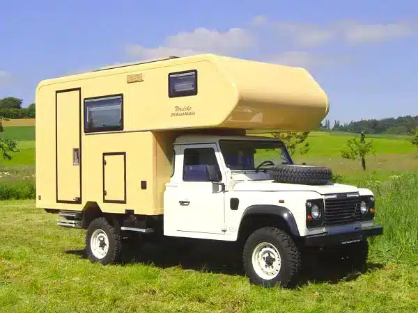 Landrover Offroad-Camper mit wintertauglichem GFK-Aufbau auf einer Wiese
