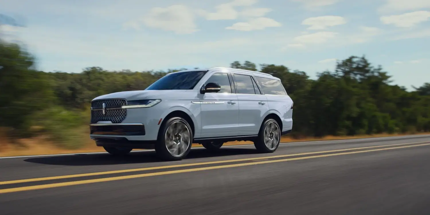 Lincoln Navigator 2027 als großes SUV auf einer Landstraße in Fahrt, Seitenansicht