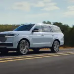 Lincoln Navigator 2027 als großes SUV auf einer Landstraße in Fahrt, Seitenansicht