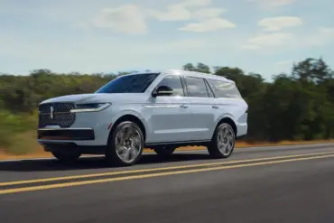 Lincoln Navigator 2027 als großes SUV auf einer Landstraße in Fahrt, Seitenansicht