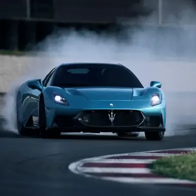 Maserati MCPura Coupé driftet auf einer Rennstrecke und erzeugt Rauch an den Hinterreifen.