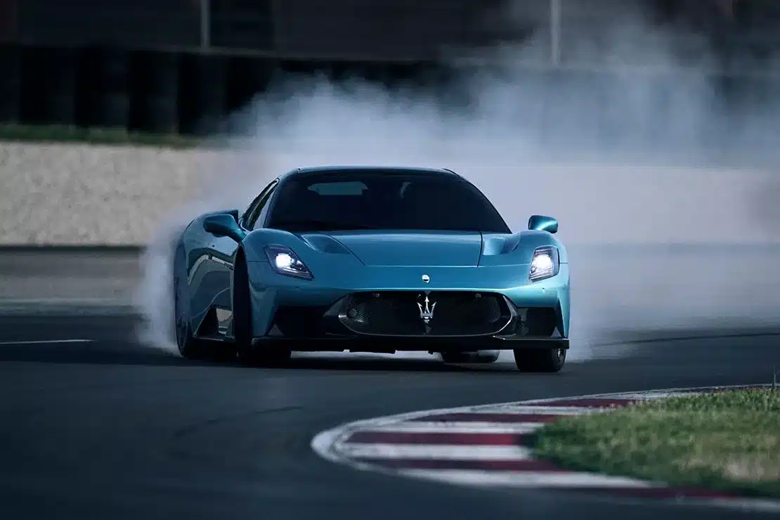 Maserati MCPura Coupé driftet auf einer Rennstrecke und erzeugt Rauch an den Hinterreifen.