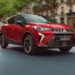 Roter Mitsubishi ASX Modell 2026 fährt auf einer städtischen Straße
