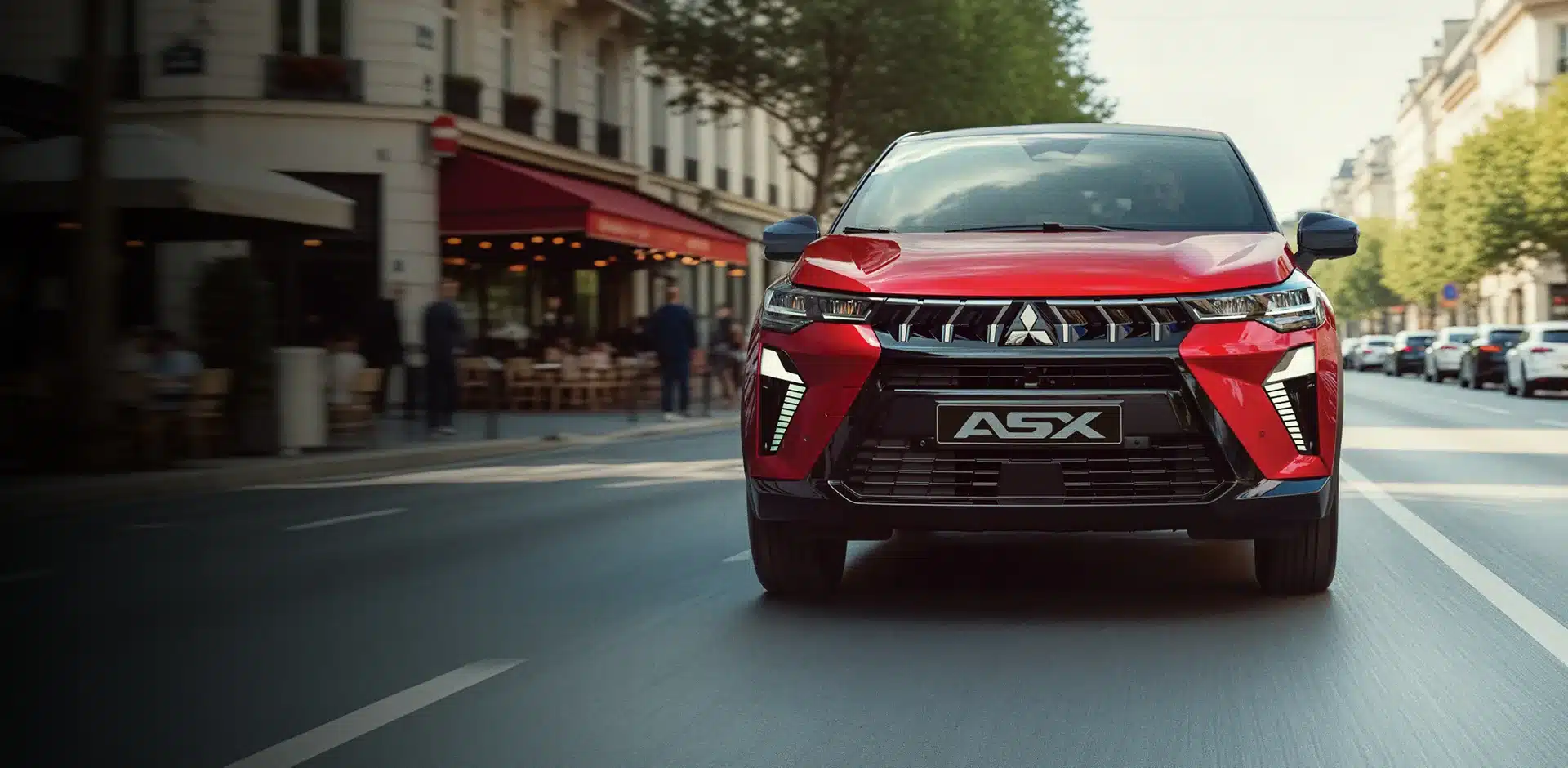 Mitsubishi ASX in Rot fährt auf einer städtischen Straße, modern gestaltete Front mit Dynamic Shield und LED-Signatur