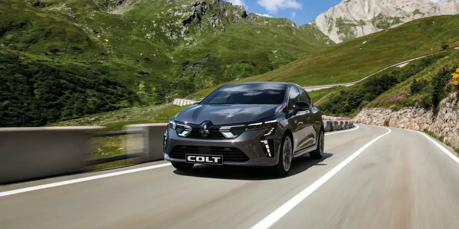 Mitsubishi COLT fährt auf einer Bergstraße bei Sonnenschein