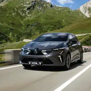 Mitsubishi COLT fährt auf einer Bergstraße bei Sonnenschein