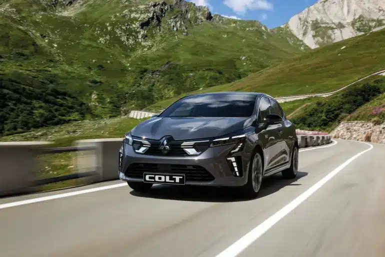 Mitsubishi COLT fährt auf einer Bergstraße bei Sonnenschein