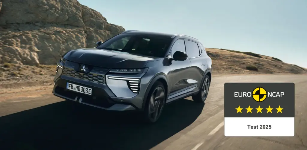 Mitsubishi Eclipse Cross Elektro-SUV fährt auf einer Landstraße, Euro NCAP 5-Sterne-Bewertung eingeblendet