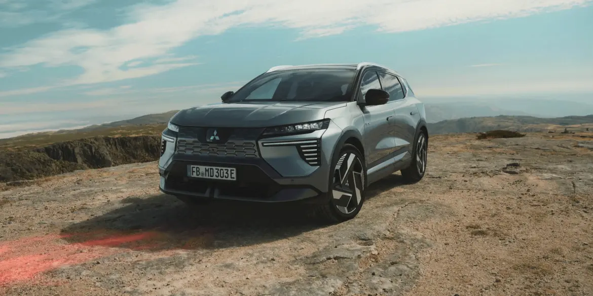 Der neue Mitsubishi Eclipse Cross Elektro-SUV steht auf felsigem Untergrund in einer offenen, bergigen Landschaft.