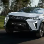 Der neue Mitsubishi Grandis Hybrid-SUV fährt auf einer von Bäumen gesäumten Landstraße.