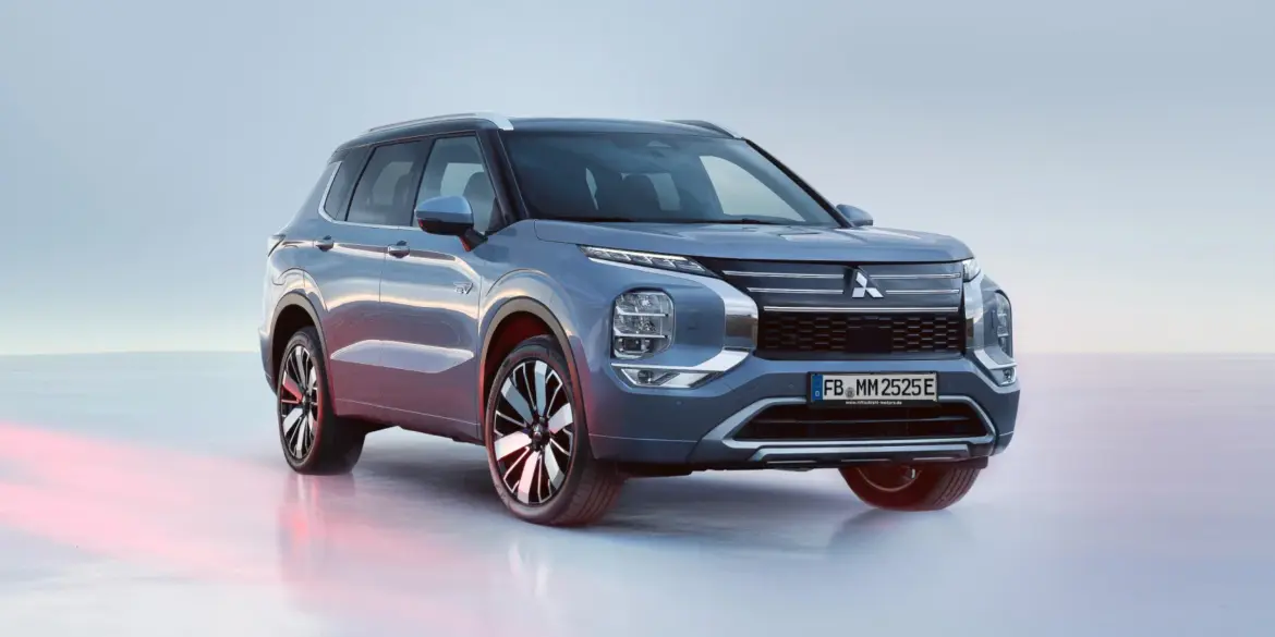 Mitsubishi Outlander Plug-in Hybrid in silberblauer Lackierung, von vorn schräg fotografiert auf heller Fläche.