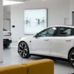 Mehrere weiße Polestar Fahrzeuge in einem modernen Showroom mit großen Fenstern und gelben Sitzmöbeln.