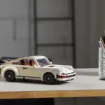 LEGO Porsche 911 Turbo Modellauto in weiß auf einem Tisch, im Hintergrund Büro-Utensilien