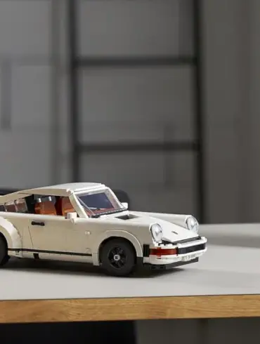 LEGO Porsche 911 Turbo Modellauto in weiß auf einem Tisch, im Hintergrund Büro-Utensilien