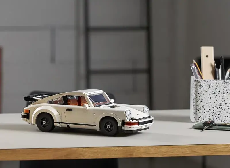 LEGO Porsche 911 Turbo Modellauto in weiß auf einem Tisch, im Hintergrund Büro-Utensilien