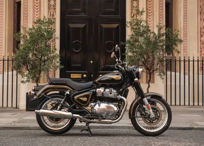 Royal Enfield Bullet 650 Cannon Black auf einer Straße, seitlich fotografiert, klassische Motive mit goldenen Details und traditionellen Formen.