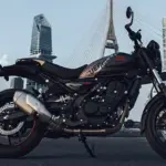 Royal Enfield Guerrilla 450 Motorrad in Seitenansicht mit moderner Stadtkulisse und Brücke im Hintergrund