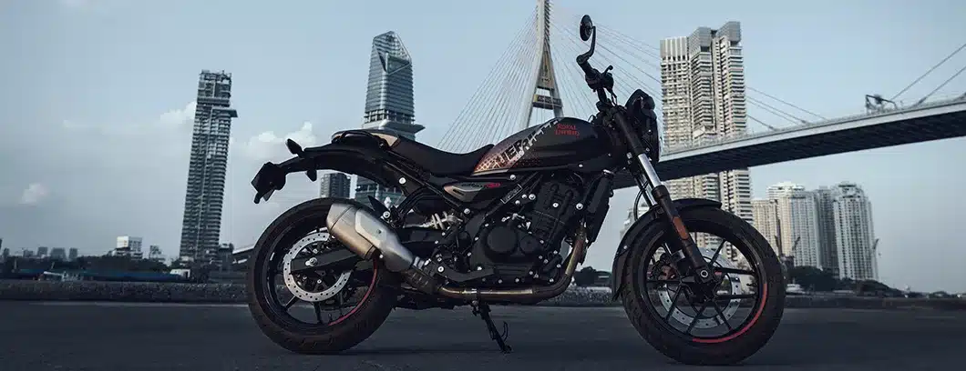 Royal Enfield Guerrilla 450 Motorrad in Seitenansicht mit moderner Stadtkulisse und Brücke im Hintergrund
