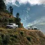 Zwei Santana 400 D Pick-ups im Offroad-Einsatz auf einem Bergweg mit Panoramablick ins Tal.