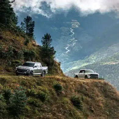 Zwei Santana 400 D Pick-ups im Offroad-Einsatz auf einem Bergweg mit Panoramablick ins Tal.