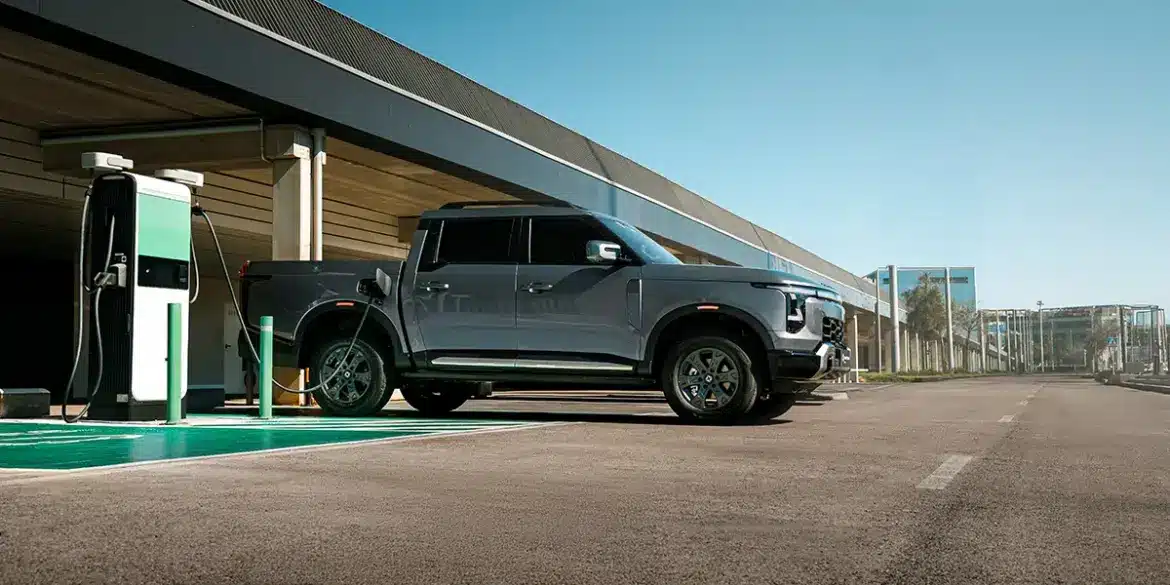 Santana 400 PHEV Pick-up beim Laden an einer E-Ladesäule auf einem Parkplatz.