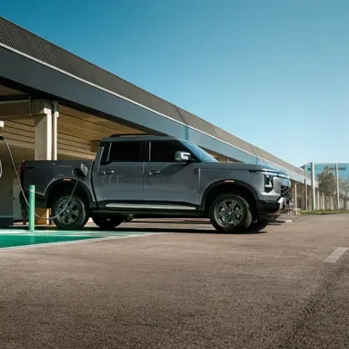 Santana 400 PHEV Pick-up beim Laden an einer E-Ladesäule auf einem Parkplatz.