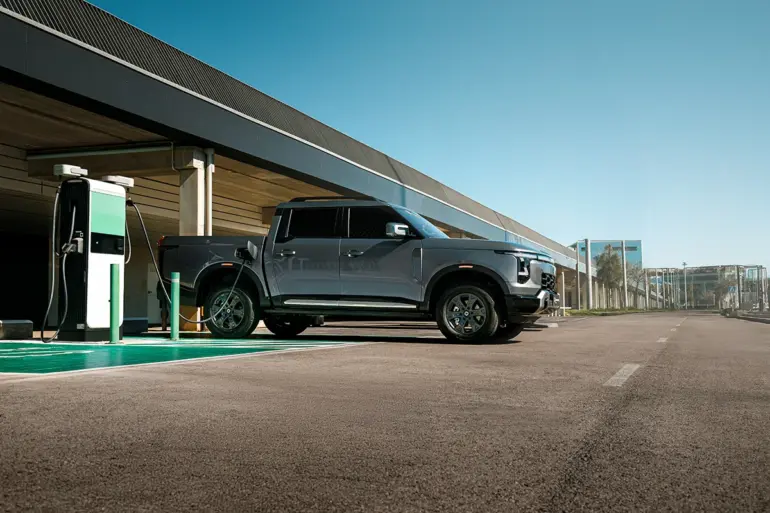 Santana 400 PHEV Pick-up beim Laden an einer E-Ladesäule auf einem Parkplatz.