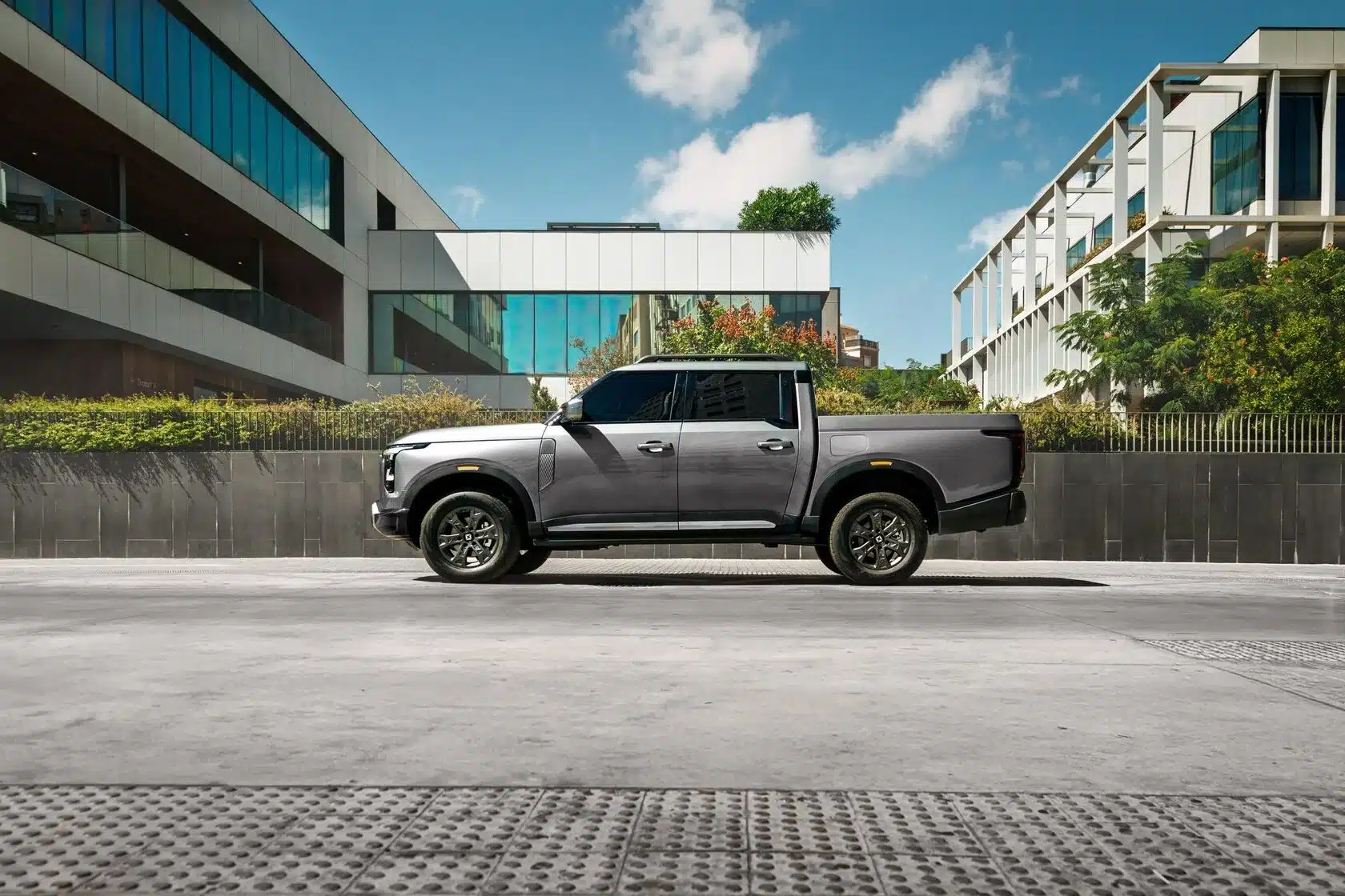 Santana 400 PHEV als Pick-up in der Seitenansicht vor moderner Architektur