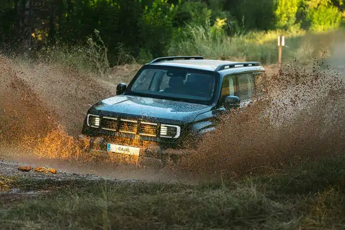 Santana Cajal Geländewagen spritzt Wasser und Schlamm beim Durchfahren einer Offroad-Strecke.