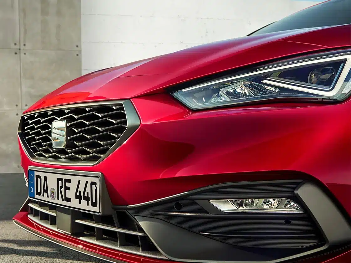 Nahaufnahme des Kühlergrills und des rechten Scheinwerfers eines roten SEAT Leon